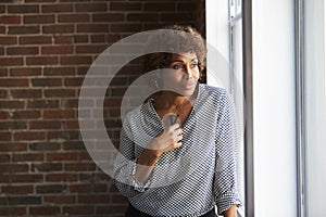 Thoughtful Mature Businesswoman Looking Out Of Office Window photo