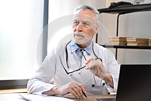 thoughtful mature male doctor pondering about diagnosis