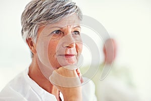 Thoughtful mature woman with blurred man. Closeup of thoughtful mature woman thinking with blurred man in background.