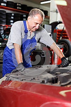 Thoughtful mechanician near repairable car photo