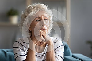 Thoughtful middle aged elder woman put head on hands.
