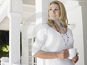 Thoughtful Middle Aged Woman With Cup Looking Away
