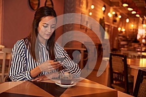 Thoughtful millenial in restaurant with phone photo