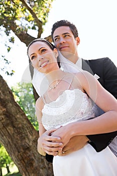 Thoughtful newly wed couple standing in garden