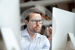 Thoughtful office worker thinking of problem solution looking at computer