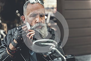 Thoughtful old bearded man shaving