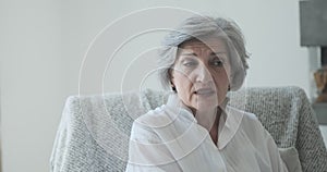 A thoughtful older woman, alone at home considering a dangerous health problem.