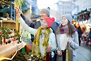 Thoughtful parents with teenage girl on the market.