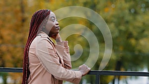 Thoughtful pensive upset young woman stands outdoors looking to side thinks about future deep in thoughts breathe fresh