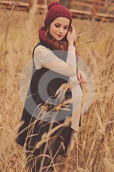 Thoughtful pregnant woman in soft warm cozy outfit walking outdoors