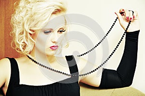 Thoughtful pretty woman with string of black beads