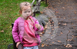 Thoughtful puzzled confused little girl child thinking park pathway alley autumn