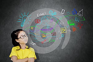 Thoughtful schoolgirl looking at doodles in a class