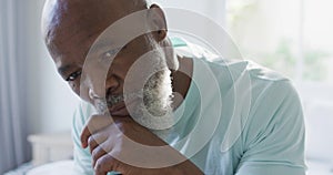 Thoughtful senior african american man in bedroom holding walking cane