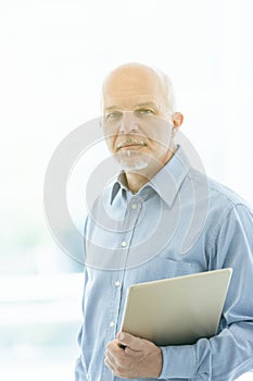 Thoughtful senior businessman staring intently at the camera