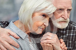 Thoughtful senior man holding hands of