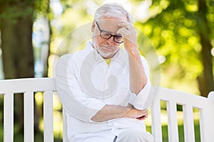 Thoughtful senior man at summer park