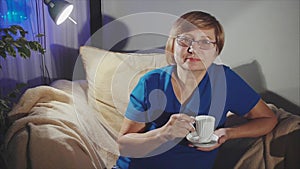 Thoughtful senior woman drinking coffee from white cup