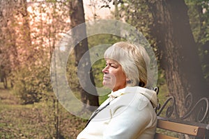 Thoughtful senior woman in hoodie  looking away in park