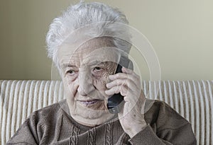 Thoughtful senior woman on phone