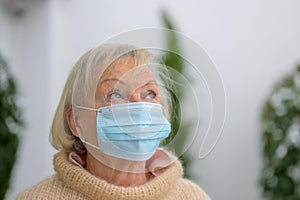 Thoughtful senior woman in a protective face mask