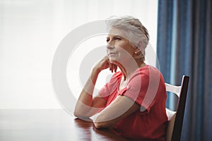 Thoughtful senior woman sitting at a table