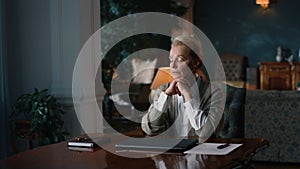 Thoughtful senior woman sitting at table in luxury cabinet. Old lady thinking