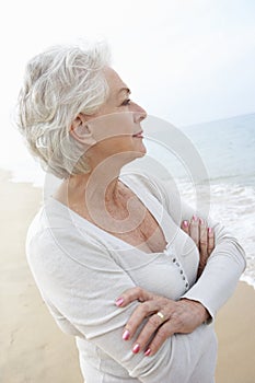 Thoughtful Senior Woman Standing On Beach