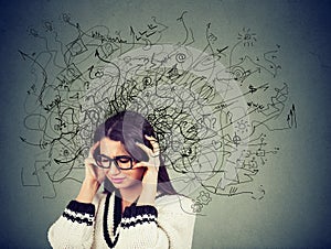 Thoughtful stressed young woman in glasses with a mess in her head