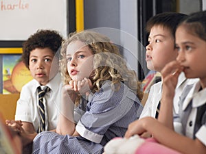 Thoughtful Students Sitting In Classroom