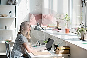 thoughtful teen student girl sitting at work desk