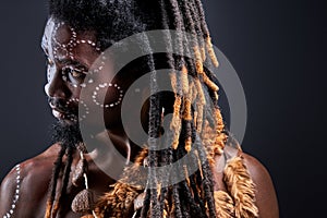 thoughtful tribal with dreadlocks looking at side