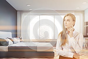 Thoughtful woman in bedroom interior