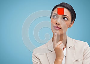Thoughtful woman with blank sticky note on her forehead