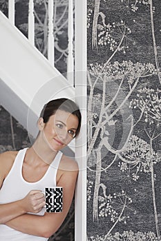 Thoughtful Woman With Coffee Mug Leaning On Door Frame