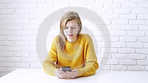 Thoughtful woman deep in thought, using smartphone