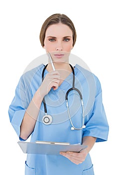 Thoughtful woman doctor keeping her clipboard