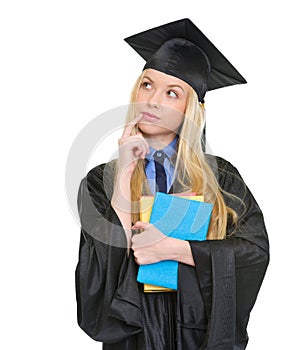 Thoughtful woman in graduation gown with books