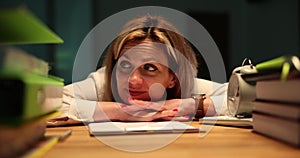 Thoughtful woman leans on table coming up with new ideas