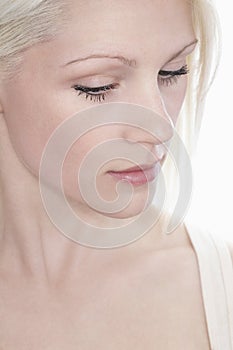 Thoughtful Woman Looking Down Against White Background