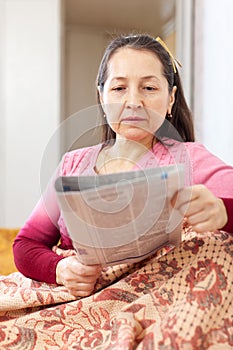 Thoughtful woman with newspaper