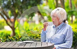 Thoughtful woman relaxing with a cup of tea or coffee