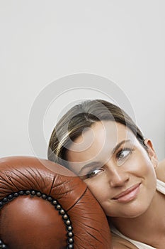 Thoughtful Woman Relaxing On Sofa's Armrest photo