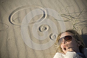 Thoughtful woman on sand