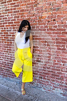 Thoughtful woman in trendy bright yellow pants