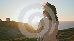 Thoughtful woman watching sunset on ocean mountain. Worried girl contemplating