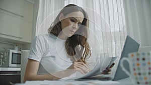 Thoughtful woman working with documents at home. Worried business woman