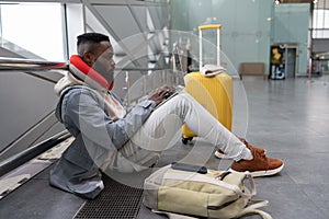 Thoughtful young black male with computer on laps preparing for exam online while waiting flight.