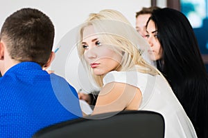 Thoughtful young business woman with a group of business people