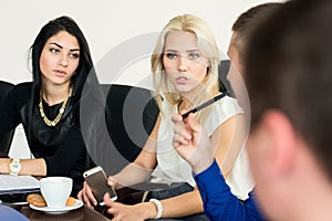 Thoughtful young business woman with a group of business people